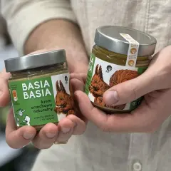 Dwie słoiki kremu orzechowego "Basia Basia" z wiewiórką na etykiecie. Czy masło orzechowe jest zdrowe? Ten naturalny krem z orzechów ziemnych odpowiada.