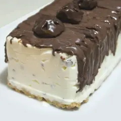 Pyszne lody cassate w czekoladzie, z kawałkami czekolady w środku, na kruchym spodzie.