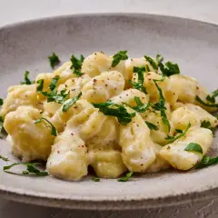 Pyszne gnocchi w kremowym sosie, posypane świeżą natką pietruszki. Idealny przepis na gnocchi z sosem, który zachwyci każdego.