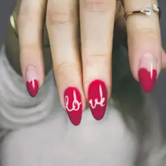 Unghie rosse con cuori e la scritta "love" in bianco. Semplici decorazioni unghie che esprimono affetto.