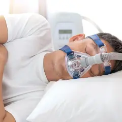 Mann schläft mit CPAP-Maske, um Atemaussetzer am Tag zu behandeln.