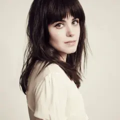 Katie Melua, jakby śpiewała "I Will Be There", z ciemnymi włosami i przenikliwym spojrzeniem.
