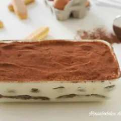 Tiramisù pronto in teglia, con strati di savoiardi e crema al mascarpone, spolverato di cacao. La ricetta perfetta per un dolce goloso.