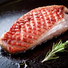 Magret de canard à la poêle, peau dorée et croustillante, avec une branche de romarin. Le temps de cuisson est idéal pour un plat savoureux.