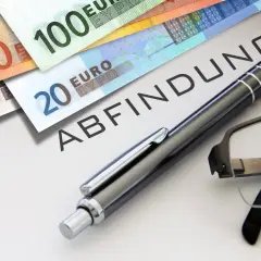 Euro-Scheine liegen auf einem Dokument mit dem Wort "ABFINDUNG". Ein Stift und eine Brille deuten auf eine bevorstehende Entscheidung oder Vereinbarung hin, vielleicht eine Abfindung nach 4 Jahren.