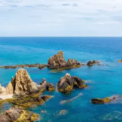 Formaciones rocosas emergen del mar turquesa, como un arrecife del dedo señalando el horizonte.