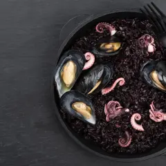 Arroz negro con mejillones y pulpo tierno, un plato de mariscos oscuro y delicioso.