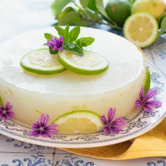 Delizioso gelo di limone, decorato con fette di limone, fiori viola e foglie di menta. Fresco e invitante.