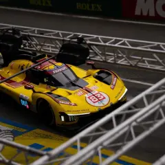 Żółto-czerwony bolid Ferrari z numerem 83 na torze podczas wyścigu Le Mans 24h.
