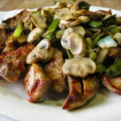Sabrosa carne de cerdo salteada con champiñones y ajos tiernos.