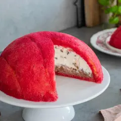 Un invitante zuccotto semifreddo, con la sua cupola rossa brillante e un cuore cremoso e goloso.