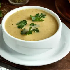 Aksamitna zupa na wielkanoc, udekorowana świeżą natką pietruszki, czeka na świątecznym stole.
