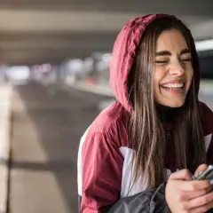Ragazza ride a crepapelle guardando il telefono, un momento che fa capire che significa lmao.