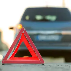 Warnblinker leuchten, ein rotes Warndreieck steht auf der Fahrbahn. Ein Auto ist liegen geblieben, ein abkommen von der fahrbahn ist nicht zu sehen.