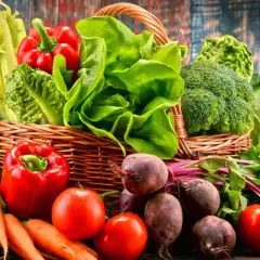 Koszyk pełen świeżych warzyw i owoców, idealnych na dietę dąbrowskiej: ananas, papryka, marchew, pomidory, buraki, brokuły, kapusta, sałata, winogrona i banany.