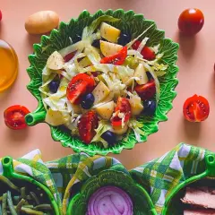Deliziosa insalata di patate napoletana con pomodorini, olive e lattuga, condita con olio d'oliva.