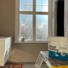 En hink med Beckers Våtrum Täckfärg står på en stege i ett badrum under renovering. Följ regler för att måla i badrum.