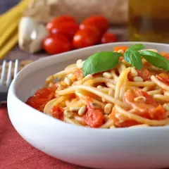 Spaghetti con pomodorini, pinoli e basilico, uno dei tanti sughi per pasta che invitano a gustare la semplicità.