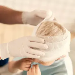 Un niño con la cabeza vendada. Si hay golpes en la cabeza de niños, cuándo preocuparse.