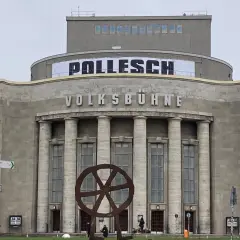 Volksbühne Berlin mit Banner "POLLENSCH". Annegret Hahn könnte hier eine Aufführung besuchen. Rote Banner mit Gebärdensprache.