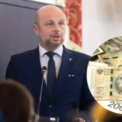 Mężczyzna w garniturze przemawia, obok okrągły fragment z polskimi banknotami 200 zł.