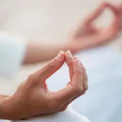 Dłonie w mudrach, symbolizujące spokój i równowagę, w geście medytacji.