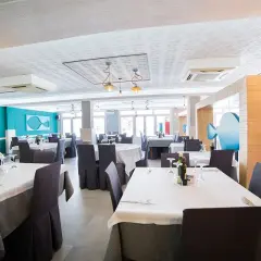 Mesas puestas en el restaurante Blanca Brisa Cabo de Gata. Ambiente marino con decoración de peces.