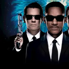 Agent J, K och O, rollistan i Men in Black 3, redo för action med sina futuristiska vapen mot en stjärnklar bakgrund.
