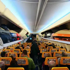 Wnętrze samolotu Ryanair, bagaże na półkach. Gdzie znajdę numer lotu Ryanair? Na ekranach przed siedzeniami.