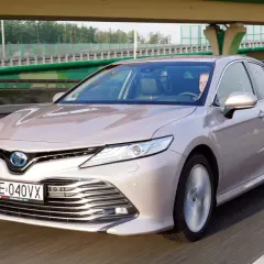 Elegancka Toyota Camry Hybrid w kolorze szampańskim na drodze. Sprawdź atrakcyjną toyota camry cena.