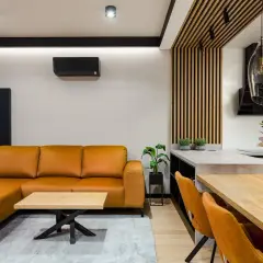 Pomarańczowa kanapa i krzesła tworzą przytulny salon inspiracje. Drewniane elementy i nowoczesne oświetlenie dodają elegancji.