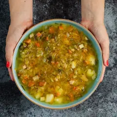 Miseczka domowej zupy ogórkowej, pełnej warzyw. Idealna na lekki posiłek, z niską zawartością kcal.
