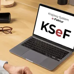 Mężczyzna pracuje przy laptopie z logo KSeF. Ułatwia to księgowanie faktur kosztowych.