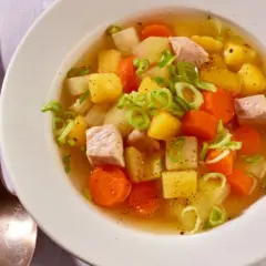 Herzhafter Kohlrabi-Eintopf mit Fleischwürfeln, Kartoffeln und Karotten, garniert mit Frühlingszwiebeln.