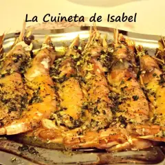 Langostinos al horno, jugosos y dorados, con hierbas y ajo, servidos en una bandeja metálica. ¡Un manjar de La Cuineta de Isabel!