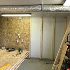 Här ligger skivor av OSB redo att måla. Verktyg och byggmaterial finns på plats för projektet.