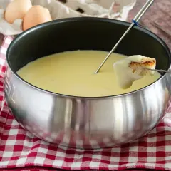 Una calda fonduta Valle d'Aosta, con pane croccante e verdure fresche, pronta per essere gustata.