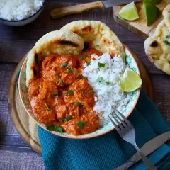 Ein köstliches Butter Chicken Rezept mit Reis, Naan und Limettenspalten. Perfekt für ein authentisches indisches Essen.