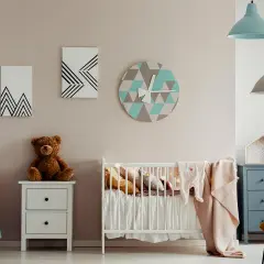 Chambre de bébé avec berceau, peluche et horloge géométrique. Une belle idée de diy deco bebe pour une chambre douce et moderne.