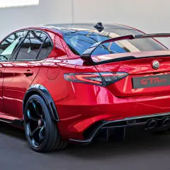 Czerwone Alfa Romeo Giulia GTAm z masywnym spoilerem i dyfuzorem, gotowe do wyścigu.