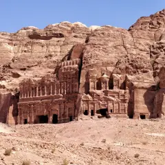Ancient rock-cut tombs and facades carved into a sandstone cliff face in Petra, Jordan.
