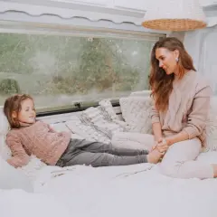 Mama i córka odpoczywają w przytulnym kamperze. Czy w kamperze można spać podczas jazdy? To pytanie zadaje sobie wielu podróżników.