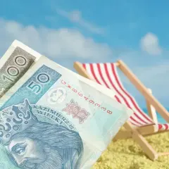Pieniądze na plaży, leżak i błękitne niebo. Czy niewypłacanie świadczenia urlopowego co to znaczy?