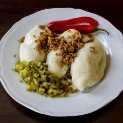 Kartacze przepis babci: sycące ziemniaczane kluski z mięsem, posypane skwarkami, z ogórkiem i papryczką chili.