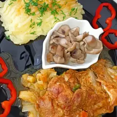 Mięso z udka kurczaka bez kości w sosie, podane z puree ziemniaczanym, marynowanymi grzybami i papryką. Idealne na obiad.