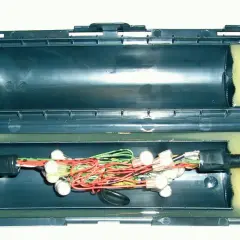 Otwarta mufa kablowa SN z widocznymi przewodami, złączkami i piankowym wypełnieniem.