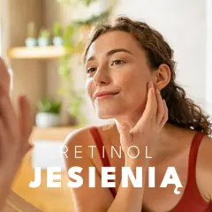 Kobieta z piegami dotyka twarzy, zastanawiając się, jak stosować retinol jesienią.