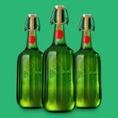 Drei grüne Flaschen Pilsner Urquell mit Bügelverschluss und rotem Siegel stehen nebeneinander.