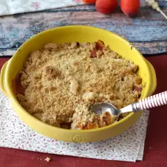 Ein goldbrauner Aprikosen Crumble in einer gelben Auflaufform, bereit zum Genießen.