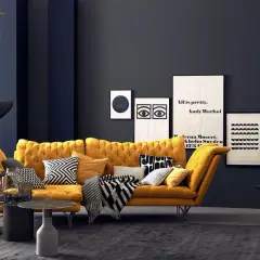 Ein senfgelbes Sofa kombiniert mit grafischen Kissen und einer dunklen Wand schafft einen modernen Look.